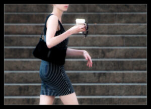 コーヒーカップを持って歩く女性
